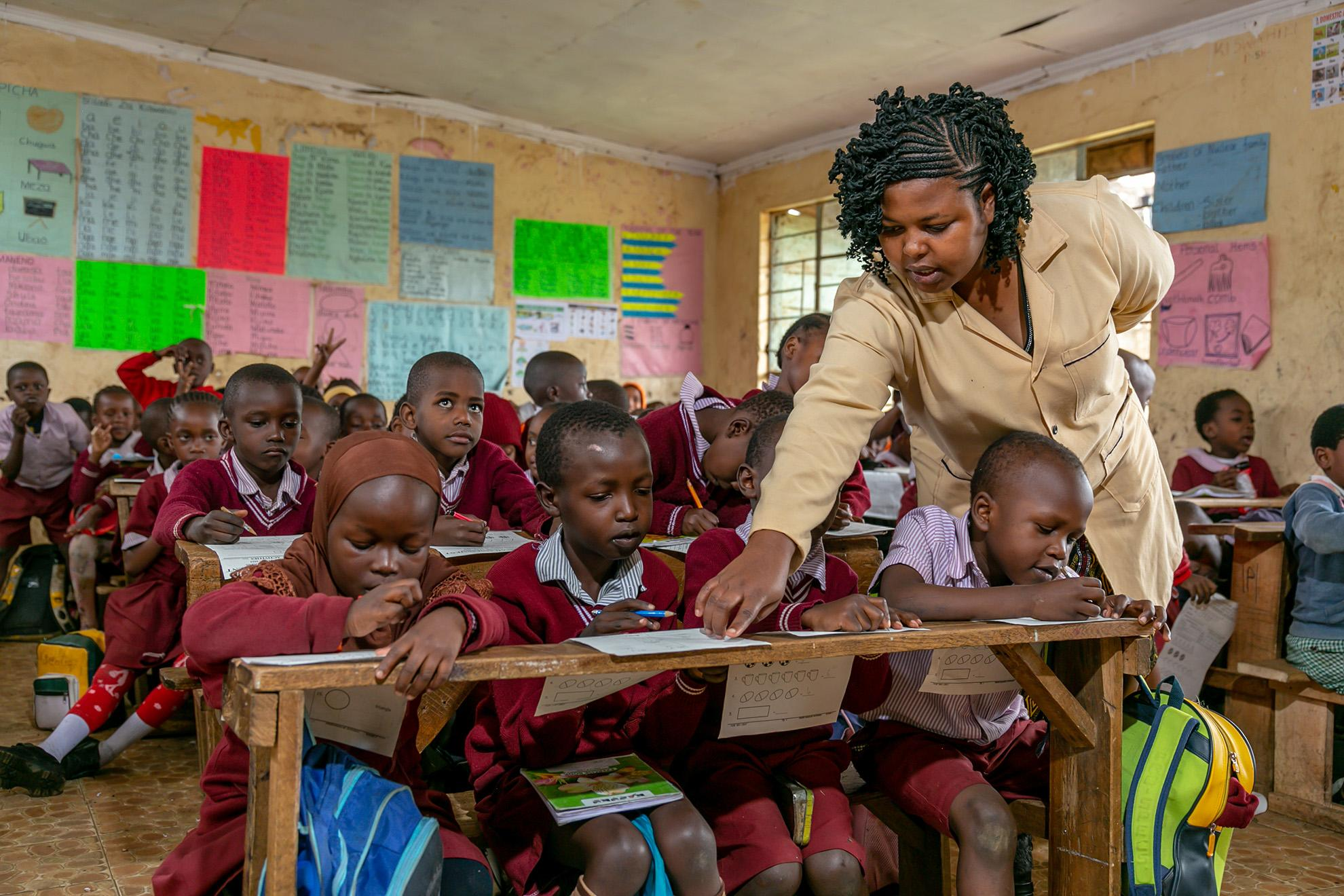 Teacher supporting pupils during a classroom lesson